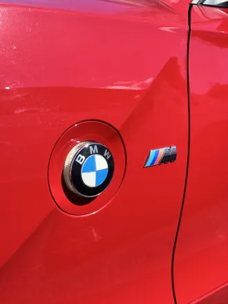 Écusson BMW et logo M sur le capot rouge du Z4 M Coupé.