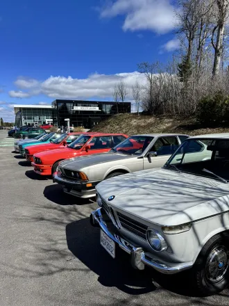 Alignement de BMW de collection, BMW 2002 crème au premier plan.