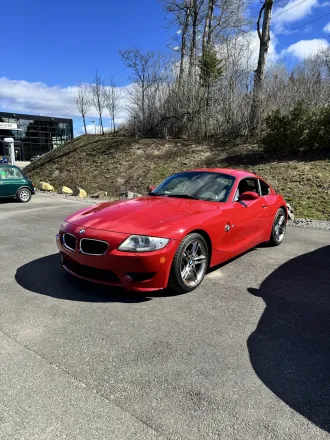 BMW Z4 M Coupé rouge, trois quarts avant, vue plus large.